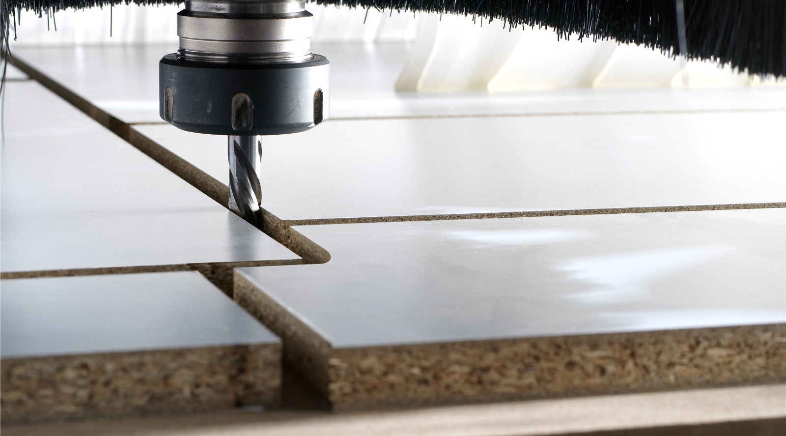 Fresa che taglia pannelli in legno laminato in un processo di lavorazione industriale di precisione.